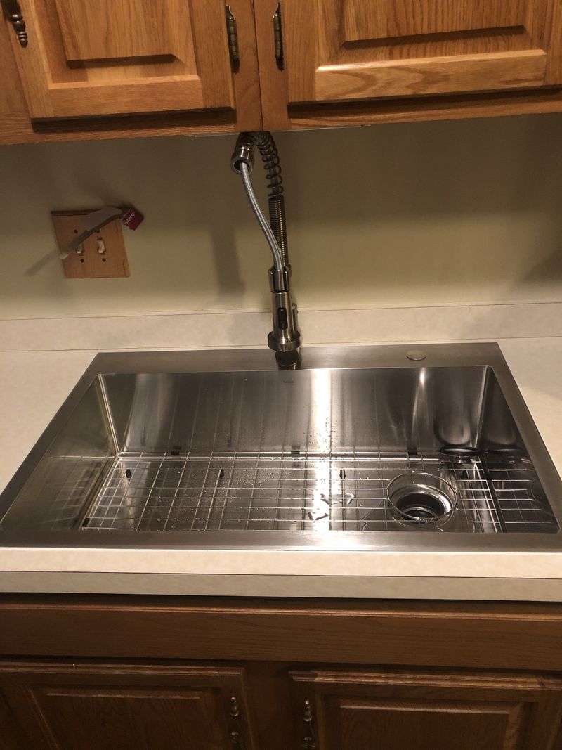 New stainless steel kitchen sink with pull-down faucet installed by Faith Mechanical